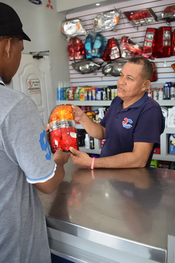 Asesor de Repuestos Carmelo mostrando un stop trasero a un cliente